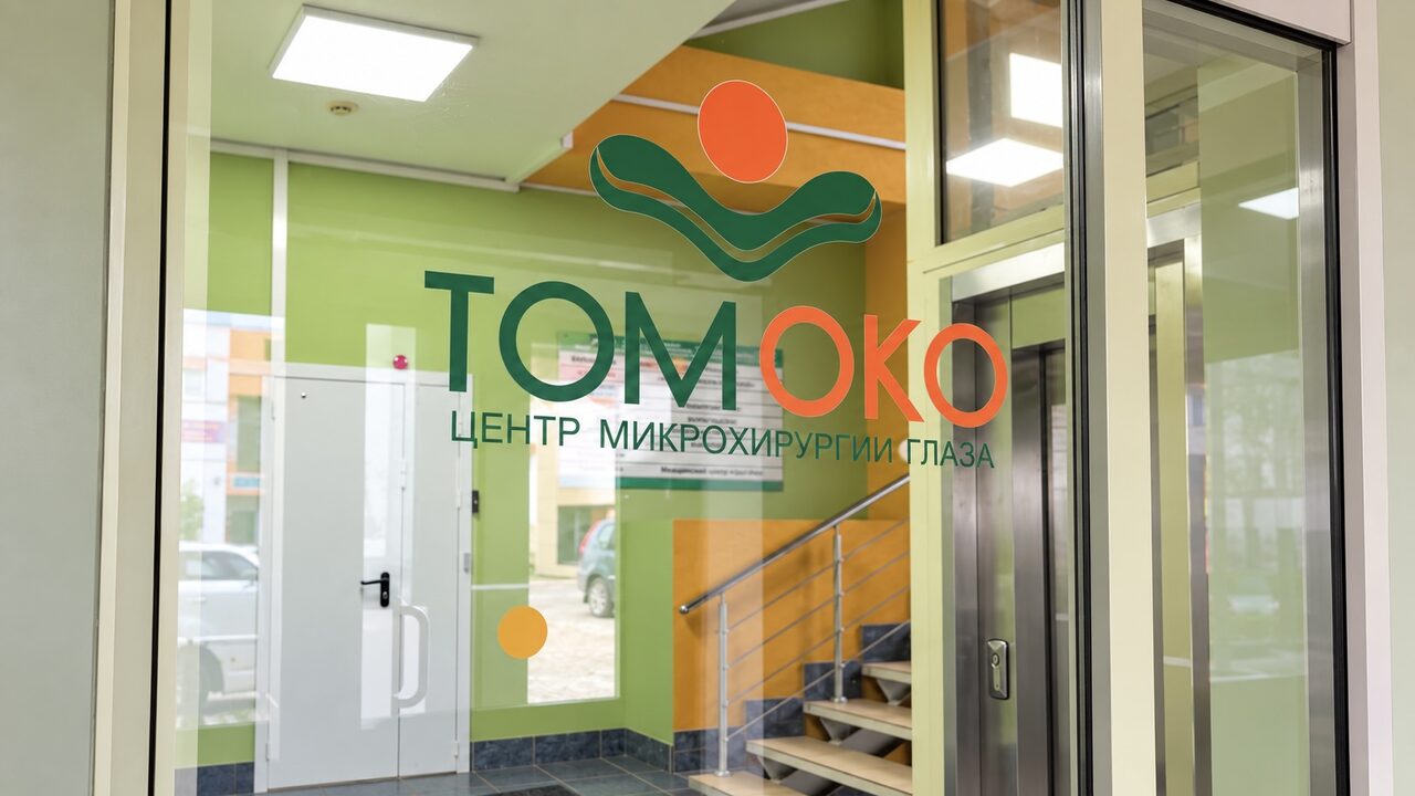 Вход в центр «ТомОко»: стеклянная дверь с логотипом и надписью «Центр микрохирургии глаза», за ней лестница и лифт